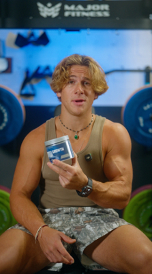 Man sitting down and holding BodyTech Elite Muscle Growth product