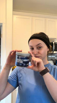 Woman holding up BodyTech Elite Muscle Growth product